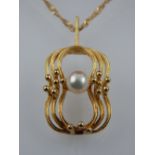 A 9ct gold and pearl set pendant, suspended on a 9ct gold chain.