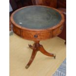 A reproduction George III style yew drum occaisional table the leather inset top fitted three