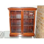 A mahogany and pine table cabinet, the moulded cornice above a pair of astragal doors enclosing