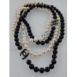 A white pearl and black glass beaded necklace, hung with enamel pendants, in the style of Chanel.