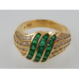 An emerald and diamond dress ring, the triple central strand with tension set shoulder in 18ct