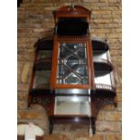 A late Victorian mirrored wall cabinet, with arched pediment over three galleried tiers and