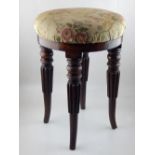 A mid 19th century mahogany piano stool, the circular upholstered seat on turned and reeded legs, D.