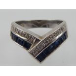 A sapphire and diamond dress ring, the emerald and round cut stones pave set in a white gold band,