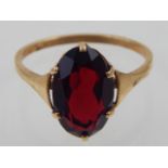 A garnet dress ring, the oval faceted stone claw set in a 9ct gold band.