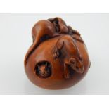 A Japanese carved boxwood netsuke modelled as rats eating a fruit, bears character mark. L. 4cm