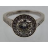 A platinum and diamond cluster ring, set central round cut stone of 1.50 carats, the mount and