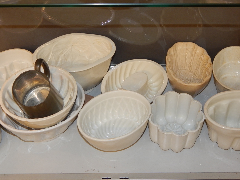 A collection of twelve Victorian and later stoneware jelly moulds, and a pewter tankard.