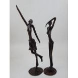In the style of Giacometti, two female bronze studies on circular bases, tallest H.