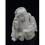 A late 19th / early 20th century ivory netsuke of a seated gentleman, H.