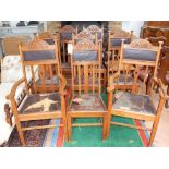 An early 20th century Arts and Crafts oak dining suite comprising eight dining chairs with carved