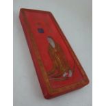 A Chinese red ground ink stone, gilt decorated with a religious figure, with Greek key border,