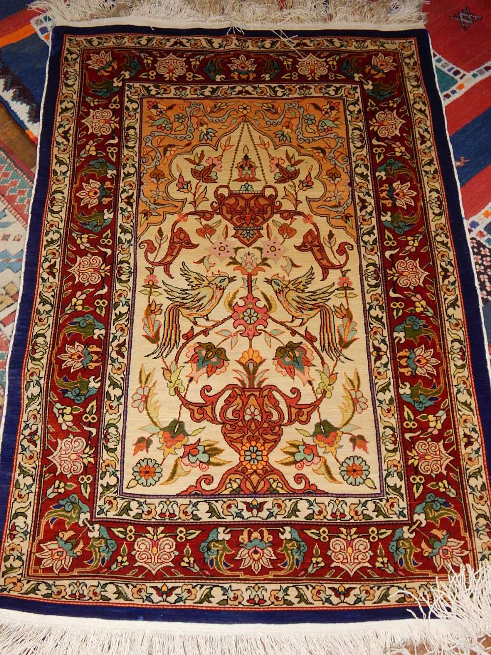 A cream ground Herkeh prayer rug, decorated with scrolling foliage and birds to centre,