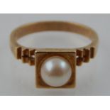 A 9ct yellow gold pearl dress ring, with pierced shoulder.