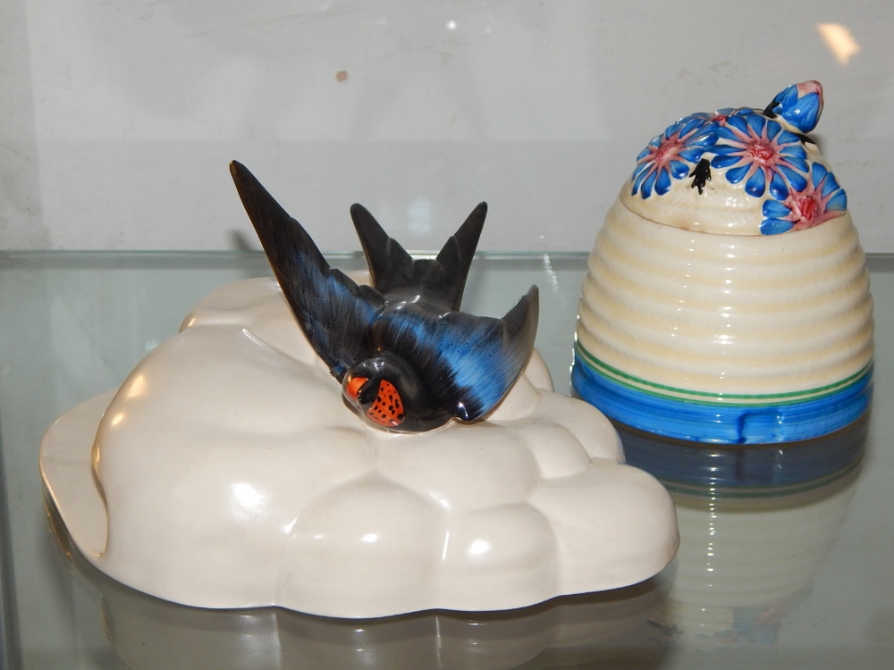 A Clarice Cliff Bizarre honey jar, decorated with blue and red flower,