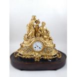 A late 19th century gilt metal mantel clock, cast with two women seated beside a stump,