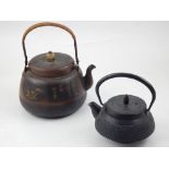 A Japanese copper teapot, decorated with vignettes of foliage and Japanese characters,