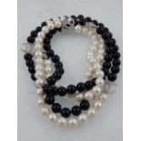 A Chanel style necklace of white pearls and black glass beads, hung with cubic zirconia set