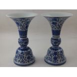 A pair of Chinese two sectioned blue and white porcelain cups, decorated with flowers,