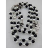 A black and white beaded faux pearl necklace, in the style of Chanel.