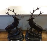 A pair of bronze stags at bay, in the manner of Landseer, raised on oval marble bases, H. 73cm, (2).