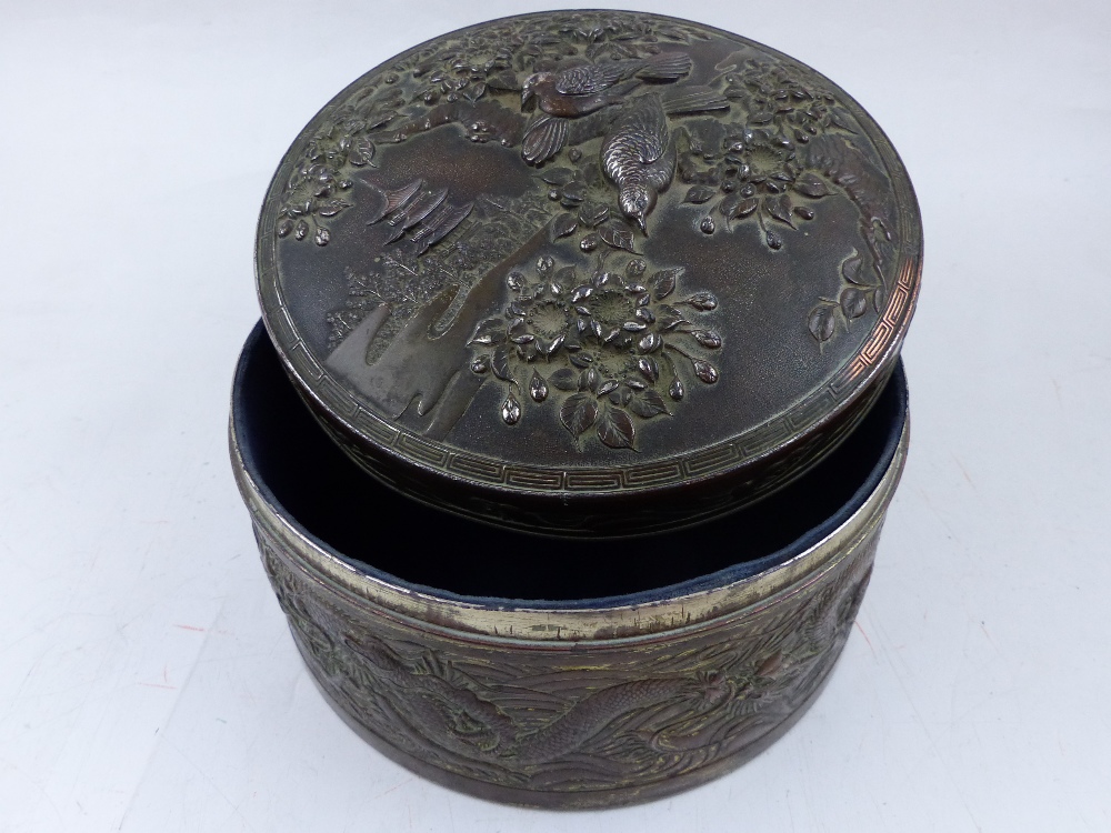 A Japanese metalware circular jewellery box, decorated with dragons, birds and flowering trees, D.