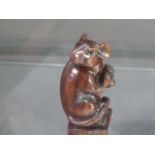 A hardwood netsuke, carved in the form of a rat, the base bearing a signature disk, H. 6cm.