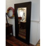 A contemporary rectangular wall mirror, with a deep dark stained oak frame, W.