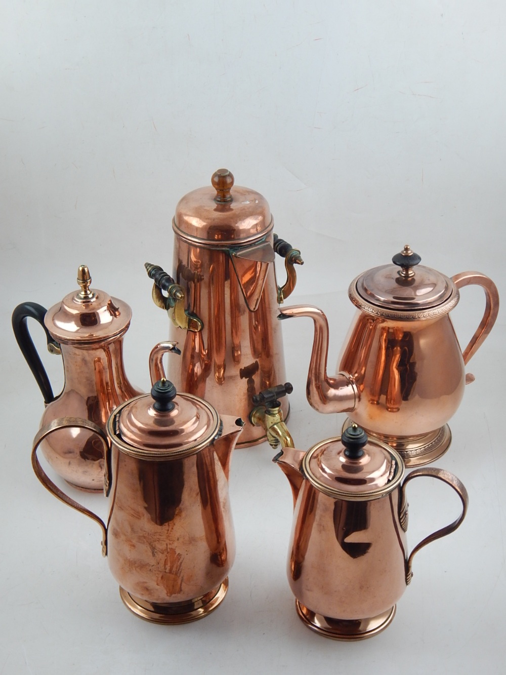 A collection of 18th century and later copper vessels including hot water jugs and chocolate pots,