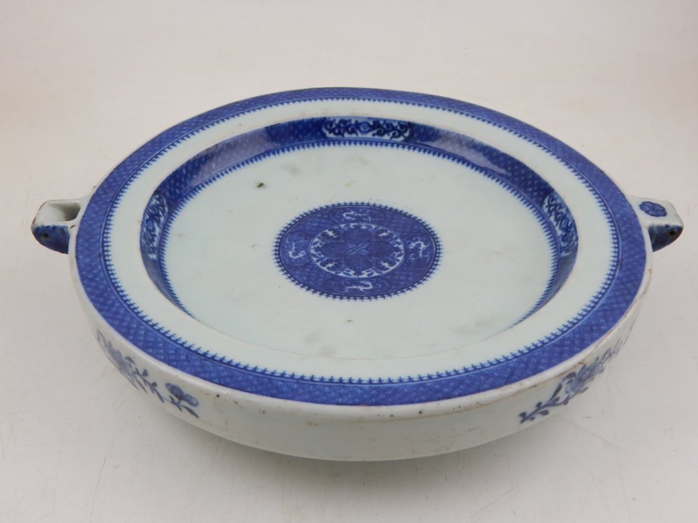 A late 19th century Chinese plate warmer, decorated in blue and white bands with floral vignettes,