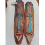 A pair of polychrome painted carved wood elongated heads,