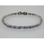 A silver, tanzanite and cubic zirconia line bracelet.