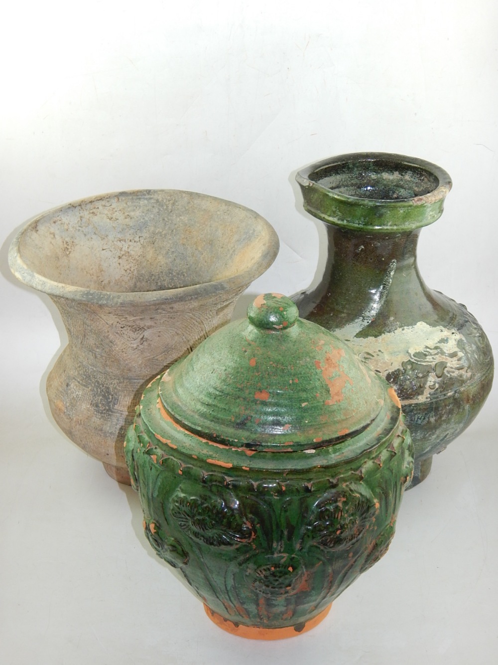 An early Chinese green glazed terracotta lidded pot, impressed with poppies, H.