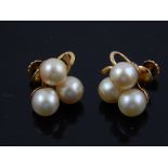 A pair of pearl ear clips, the three peals mounted in yellow metal stamped 14ct, 5.5g.