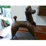 A bronze metal model of a standing poodle.