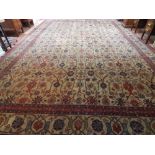 A large Persian rug, overall with stylised floral design on a beige ground, fringed, L.510cm, W.