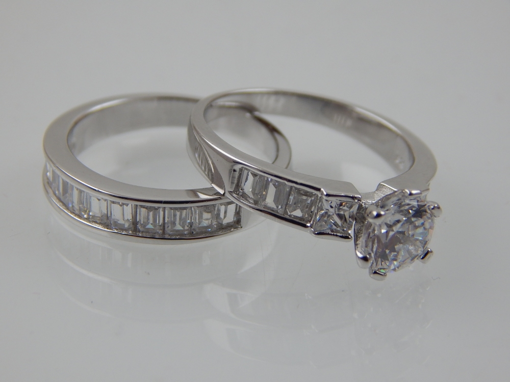 A silver and cubic zirconia ring and band set circular and baguette stones.