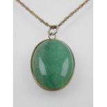 A jade and silver mounted cabuchon pendant, Birmingham, suspended on a white metal chain.