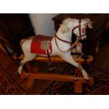 A mid 20th century carved wood and gesso dapple grey rocking horse, raised on a turned beech