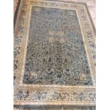 A green ground Chinese rug, decorated with scrolling geometric pattern, within cream border,
