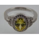 A silver and cubic zirconia dress ring, set oval yellow stone.