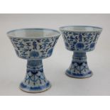 A pair of Chinese blue and white porcelain stem cups, decorated with stylised flowers,