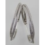 A pair of silver and cubic zirconia hoop earrings of twist two-strand form.