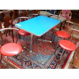 A rectangular American Diner table, blue and chrome with six red and chrome tub frame chairs.