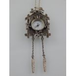 A silver quartz clock pendant, suspended on a silver chain, stamped 925.