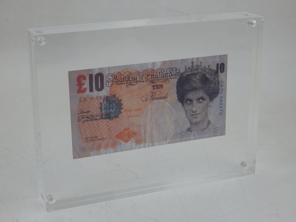 A Banksy Di-Faced ten pound note, presented within an acrylic frame, W. 20cm.