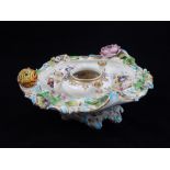 An early 20th century porcelain inkwell, decorated with encrusted flowers,