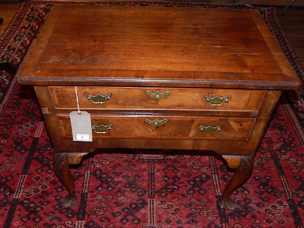 An 18th century and later walnut lowboy, with crossbanded top over two drawers, raised on cabriole