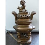 A Chinese bronze incense burner, rectangular with a dog of Fo surmount and mask handles, on a stand,