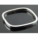 A modern silver bangle of hinged rectangular form.